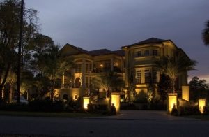 Large home with outdoor lighting turned on at dusk.