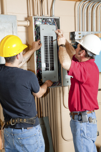 two electricians inspecting an electrical panel