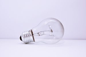 Light bulb on white table with white background.
