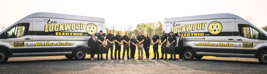 Lon Lockwood Electric's team standing in front of two service vans